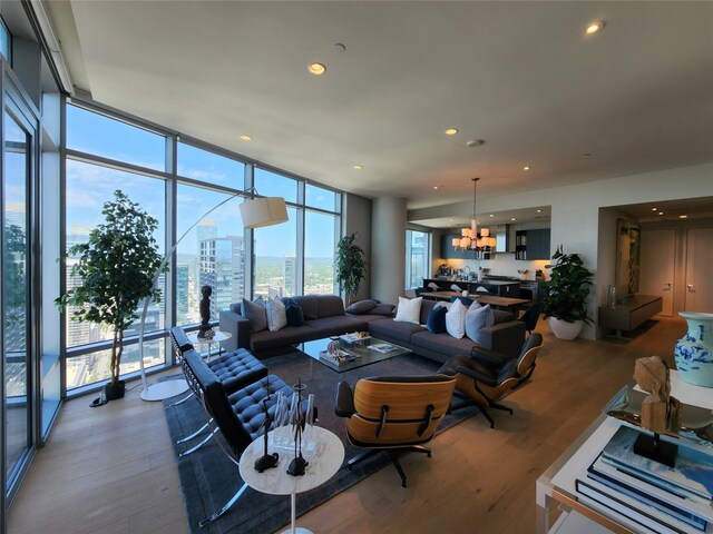 living room with floor to ceiling windows, hardwood / wood-style flooring, and a chandelier