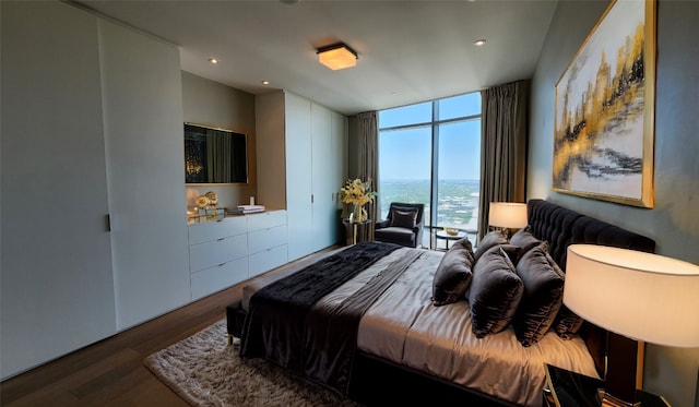 bedroom with hardwood / wood-style floors and floor to ceiling windows