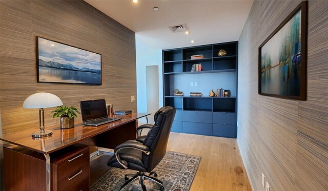 office area with light wood-type flooring and built in desk