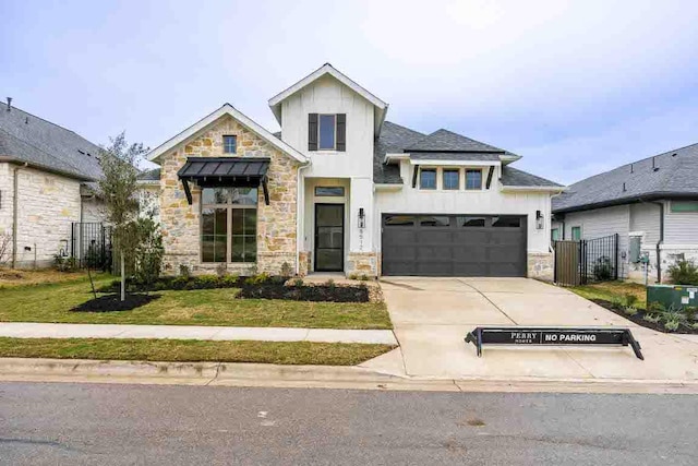 view of front of property featuring driveway, stone siding, fence, and a front yard