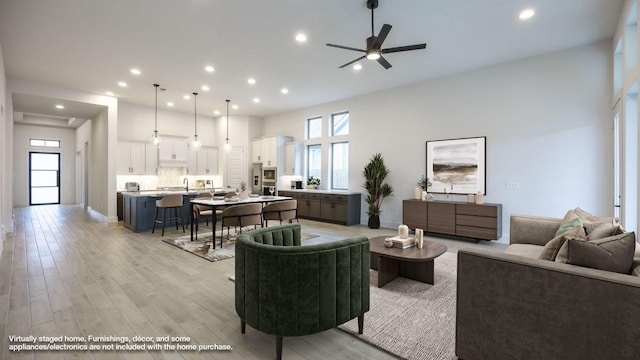 living room featuring a wealth of natural light, light wood finished floors, and recessed lighting