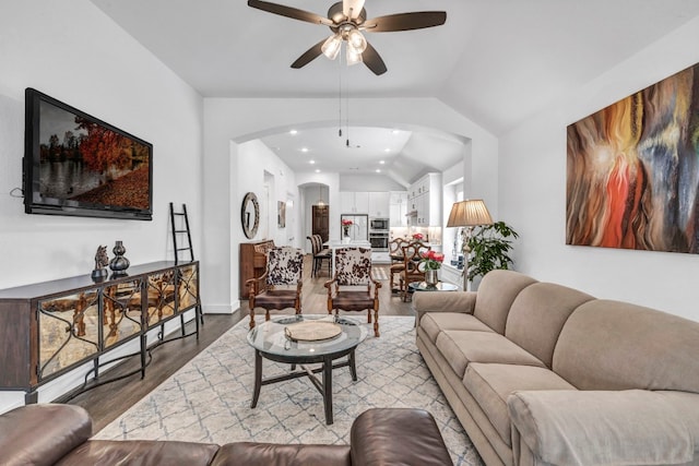 living room with ceiling fan, vaulted ceiling, and light hardwood / wood-style flooring