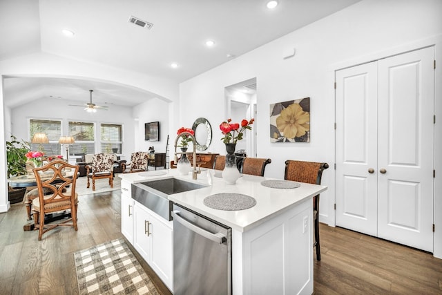 kitchen with a center island with sink, a sink, ceiling fan, dishwasher, and wood finished floors