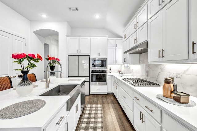 kitchen with backsplash, sink, dark hardwood / wood-style flooring, appliances with stainless steel finishes, and white cabinetry