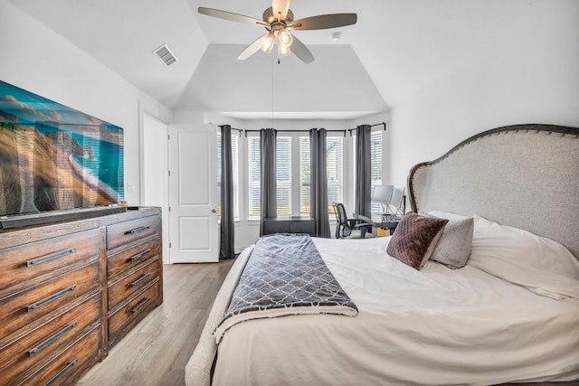 bedroom featuring ceiling fan, light hardwood / wood-style floors, and lofted ceiling