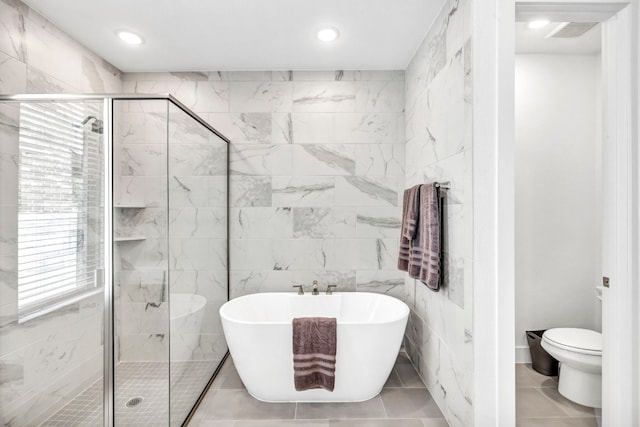 bathroom with plus walk in shower, tile walls, toilet, and tile patterned floors