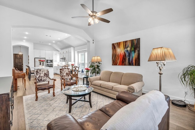 living room with ceiling fan, light hardwood / wood-style flooring, and lofted ceiling