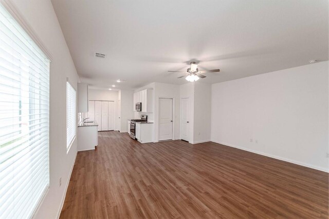 unfurnished living room with ceiling fan and hardwood / wood-style flooring