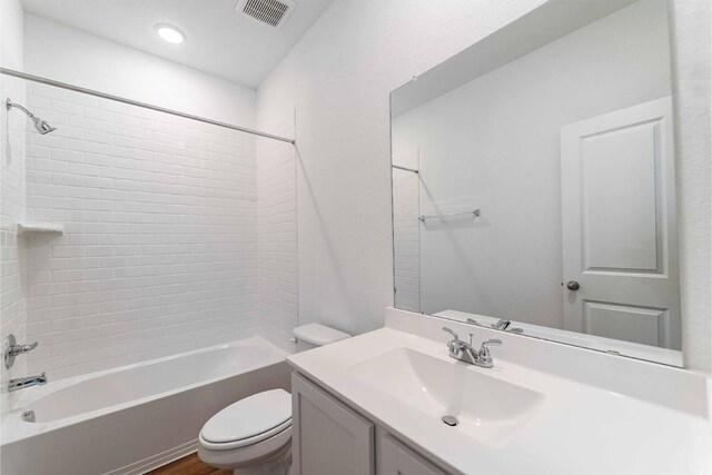 full bathroom with vanity, toilet, and tiled shower / bath