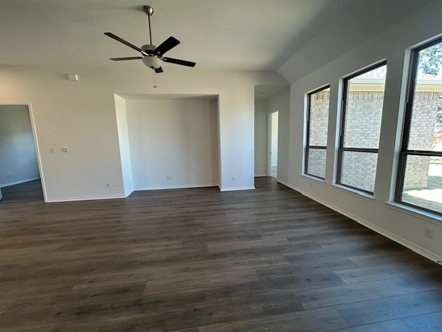 spare room featuring dark wood-type flooring, ceiling fan, and baseboards