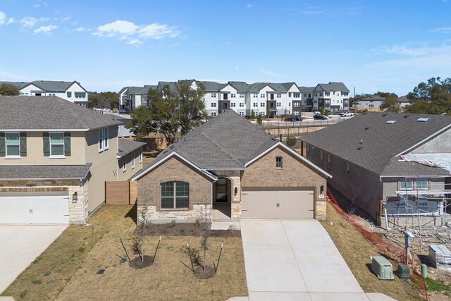 520 Raleigh Dr, Georgetown, TX 78633 - view of front of house featuring a residential view, concrete driveway, stone siding, and an attached garage