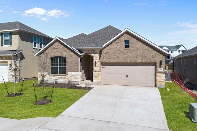 520 Raleigh Dr, Georgetown, TX 78633 - view of front of house featuring concrete driveway, a front yard, a garage, and stone siding