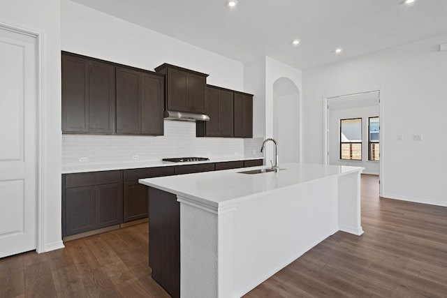 520 Raleigh Dr, Georgetown, TX 78633 - kitchen with dark wood-style floors, backsplash, an island with sink, under cabinet range hood, and gas cooktop