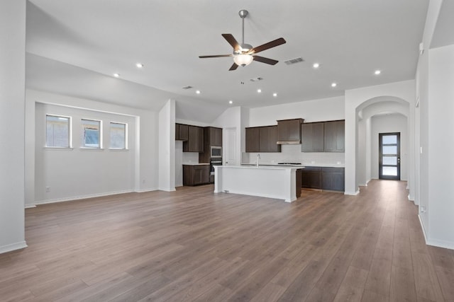 520 Raleigh Dr, Georgetown, TX 78633 - kitchen featuring open floor plan, ceiling fan, dark brown cabinets, lofted ceiling, and a center island with sink
