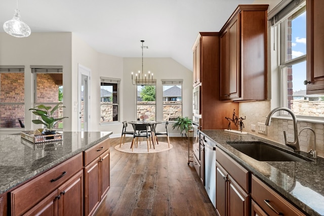 kitchen featuring sink, dark wood-type flooring, stainless steel dishwasher, backsplash, and pendant lighting