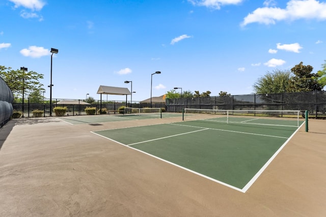 view of tennis court featuring basketball hoop