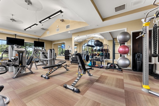 gym featuring light carpet, high vaulted ceiling, and ceiling fan