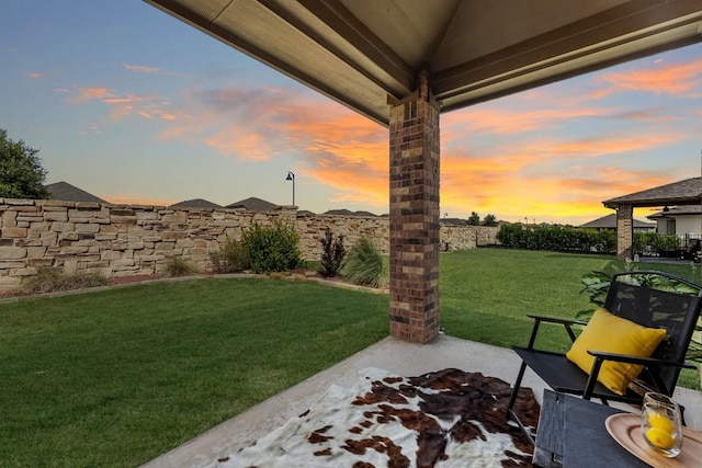 yard at dusk featuring a patio area