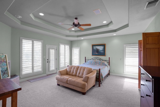 carpeted bedroom with a raised ceiling, ceiling fan, and access to outside