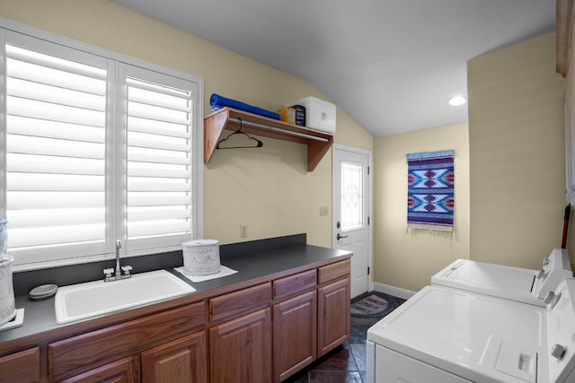 laundry area with washing machine and clothes dryer, sink, cabinets, and dark tile patterned flooring