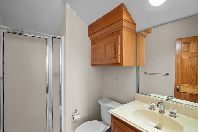 bathroom featuring vanity, toilet, and a shower with shower door