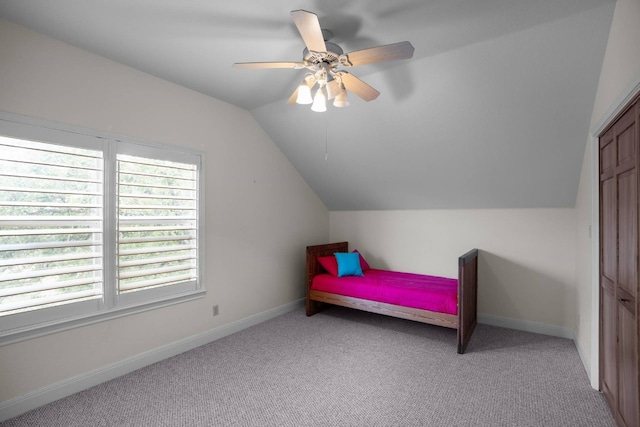 bedroom featuring ceiling fan, a closet, light colored carpet, and vaulted ceiling