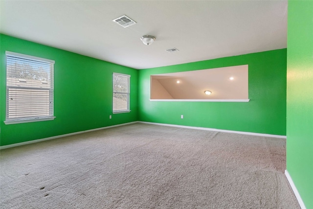 unfurnished room featuring plenty of natural light and carpet