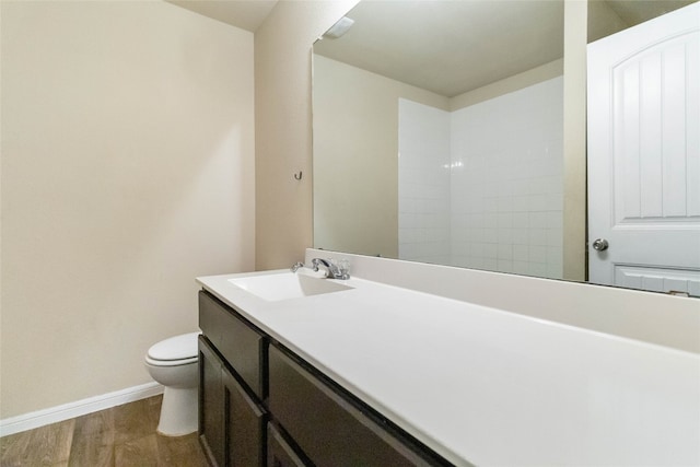 bathroom with vanity, toilet, and hardwood / wood-style floors