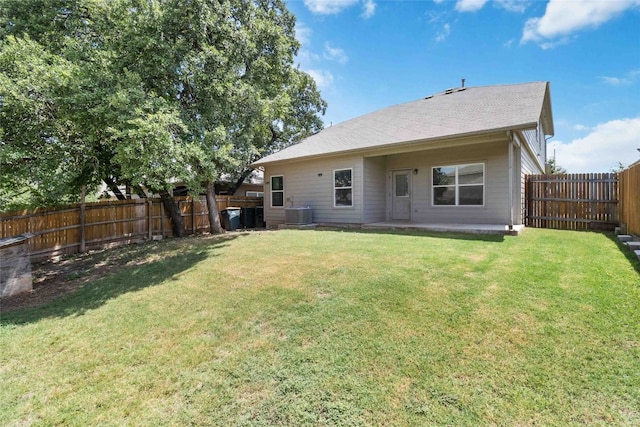 rear view of property with central air condition unit, a patio, and a yard