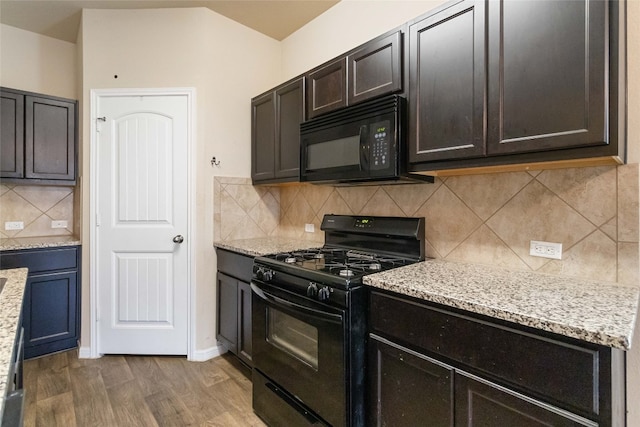 kitchen with light stone counters, dark brown cabinets, black appliances, backsplash, and wood-type flooring