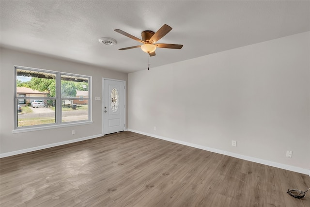 unfurnished room with hardwood / wood-style floors, a textured ceiling, and ceiling fan