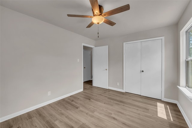 unfurnished bedroom with ceiling fan, light hardwood / wood-style flooring, and a closet