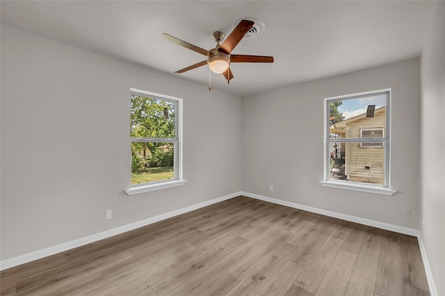 empty room with ceiling fan and light hardwood / wood-style flooring