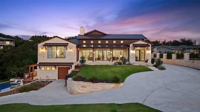 back house at dusk with a garage