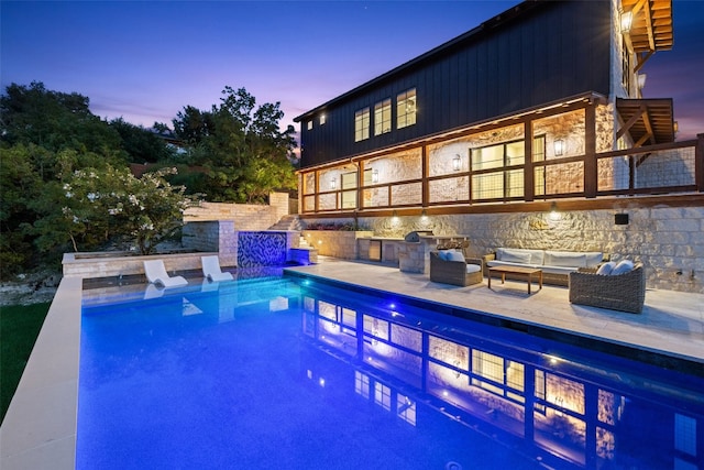 pool at dusk featuring an outdoor hangout area and a patio area