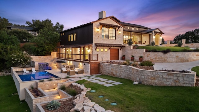 back house at dusk featuring a lawn, a patio, and an outdoor fire pit