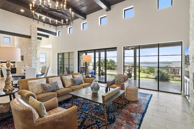 living room with wooden ceiling, a towering ceiling, beam ceiling, and a chandelier