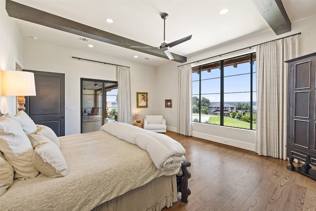 bedroom with ceiling fan, wood-type flooring, beamed ceiling, and multiple windows