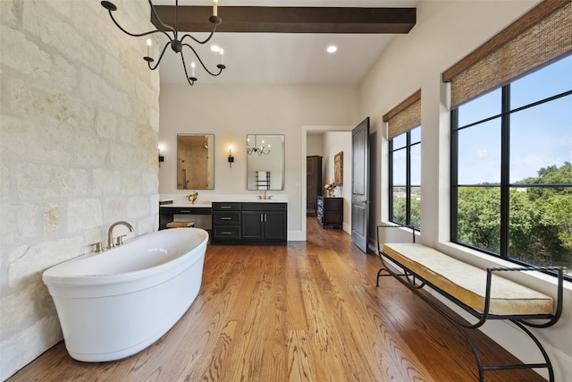 bathroom featuring hardwood / wood-style floors, tile walls, a notable chandelier, beamed ceiling, and a bath