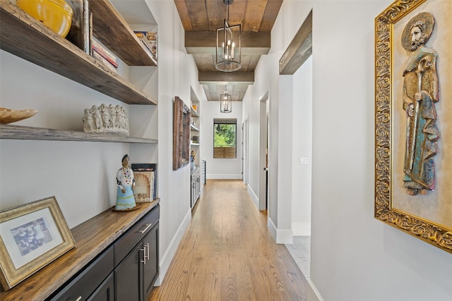 hall with light wood-type flooring and wood ceiling