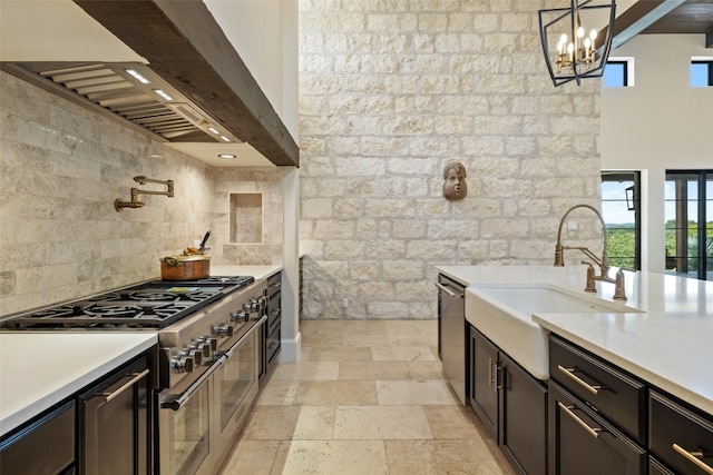 kitchen featuring pendant lighting, a notable chandelier, stainless steel appliances, light tile patterned floors, and sink