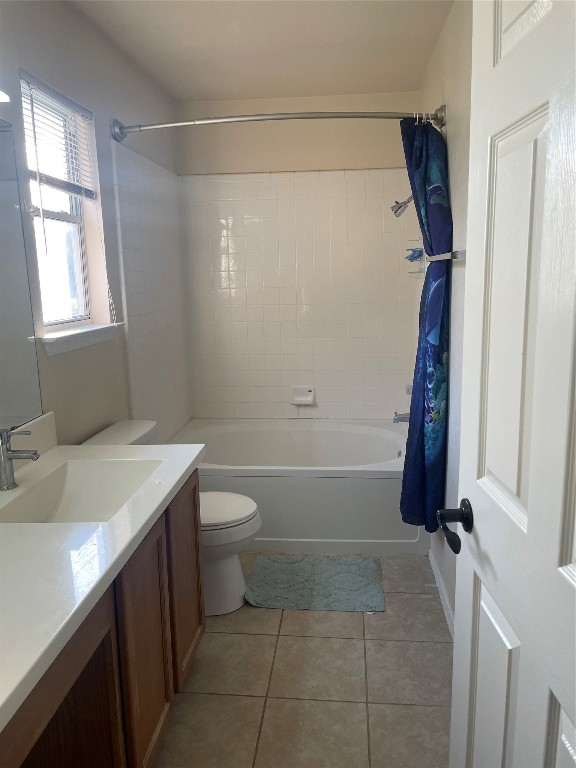 full bathroom with tile patterned floors, vanity, shower / tub combo, and toilet