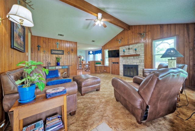 living room with plenty of natural light, ceiling fan, wooden walls, and a fireplace