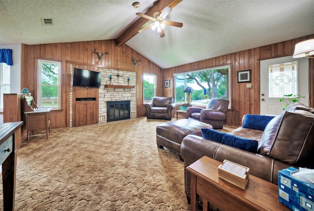 carpeted living room featuring a textured ceiling, plenty of natural light, ceiling fan, and a fireplace