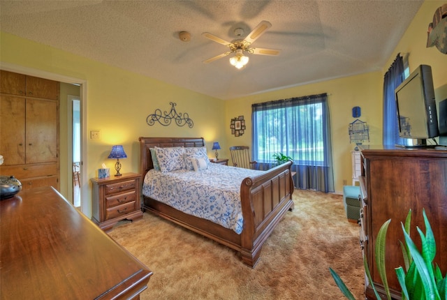 bedroom featuring a textured ceiling, ceiling fan, and light carpet