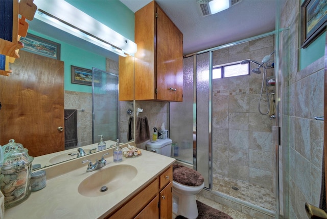 bathroom featuring vanity, toilet, walk in shower, and a textured ceiling