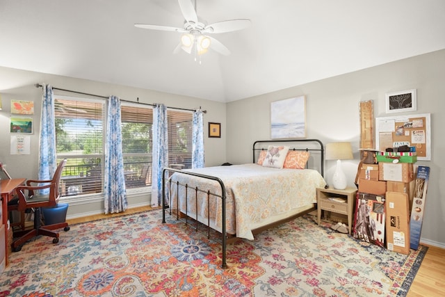 bedroom with ceiling fan, light hardwood / wood-style flooring, and lofted ceiling