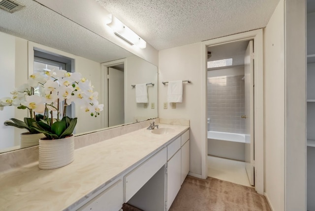 bathroom with shower / bathtub combination, a textured ceiling, and vanity