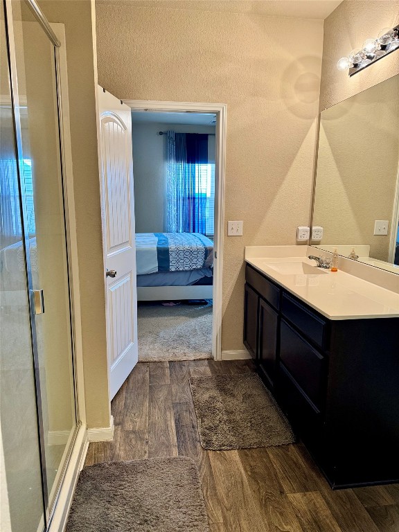 bathroom featuring vanity, walk in shower, and hardwood / wood-style flooring