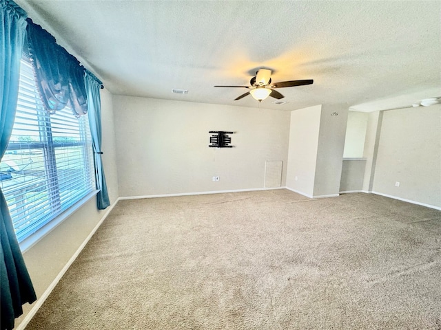 unfurnished room with a textured ceiling, carpet, and ceiling fan